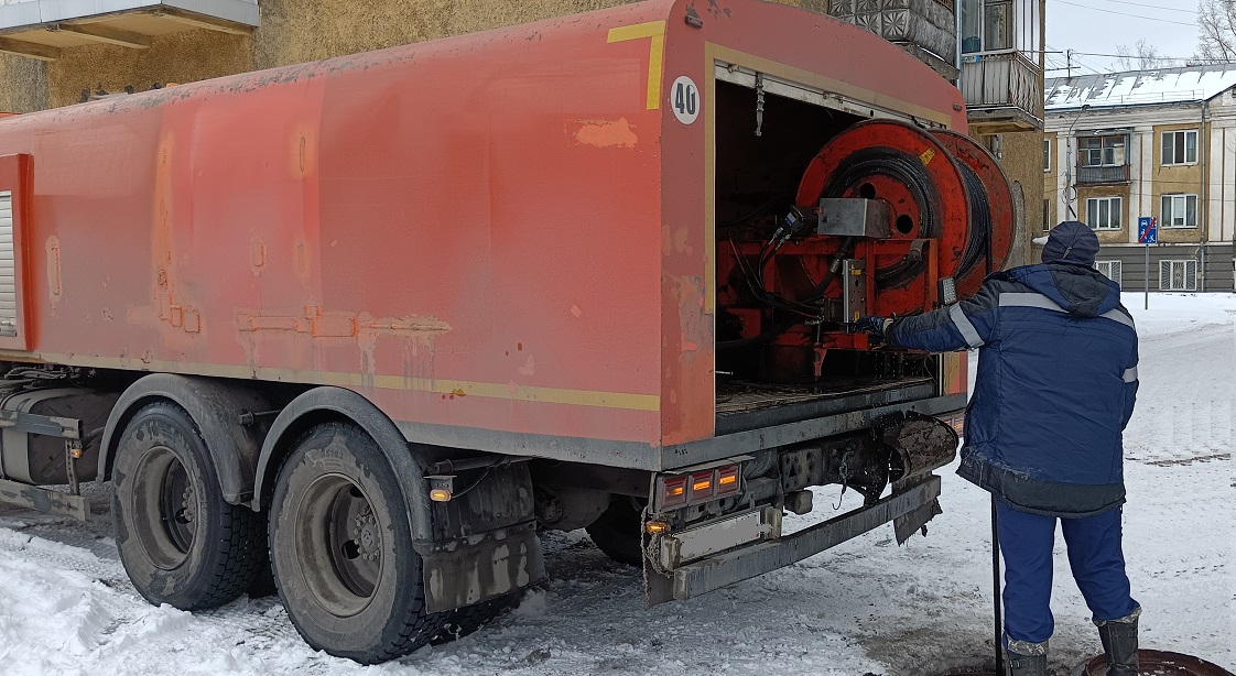 Каналопромывочная машина и работник прочищают засор в канализационной системе в Адыгее